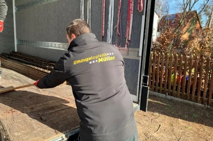 umzugshelfer zieht ladeflaeche im umzugswagen leer